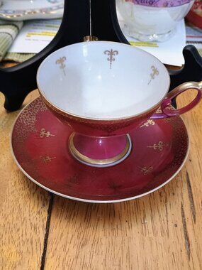 This is a vintage magenta or deep red tea cup and saucer set
